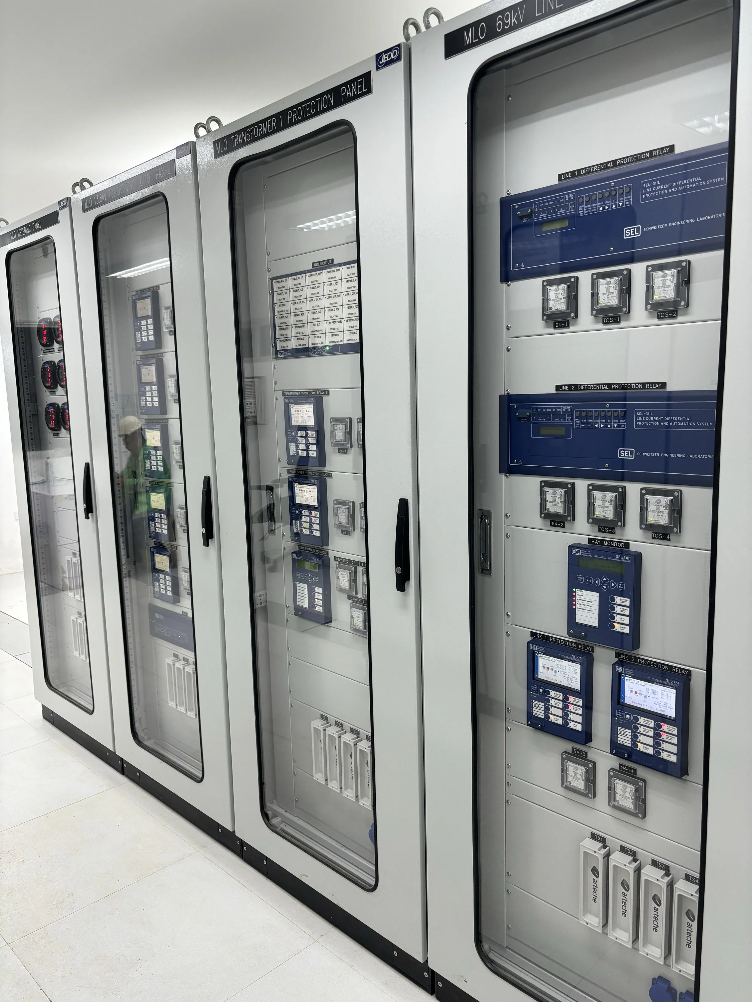 Series of electrical control panels and relays inside a data center or utility room.